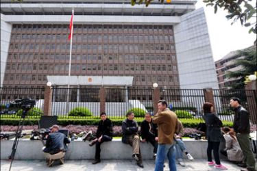 afp : Plainclothes security personel sit among waiting journalists outside the Shanghai No.1 Intermediate People's Court on March 29, 2010 during the convinction of four