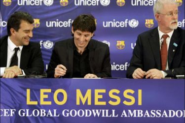 r : Barcelona's player Lionel Messi of Argentina signs an agreement to undertake the role of UNICEF Goodwill Ambassador for two years next to Barcelona F.C's President