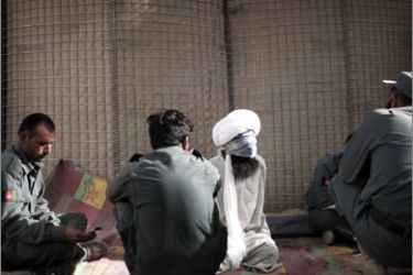 A detainee is interrogated by Afghan policemen at a US Marine base for 3rd Battalion, 6th Marines in Marjah, Helmand province, on April 7, 2010. A single Afghan