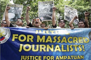 A group of journalists raise their clenched fists as they shout anti-government slogans during a protest outside the Department of Justice in Manila