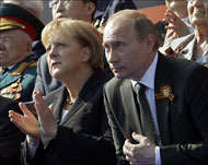 رئيس الوزراء الروسي إلى جانب المستشارة الألمانية أثناء الاحتفال (رويترز)