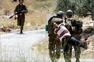AFP- Israeli forces arrest a Palestinian man during clashes following a protest against land confiscation and Israeli settlements in the West bank village of Bilin on May 07, 2010