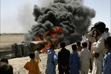 r_Afghans watch a burning fuel tanker after an explosion caused by a bomb in Jalalabad, eastern Afghanistan May 28, 2010. The truck was on its way to supply fuel to a NATO base
