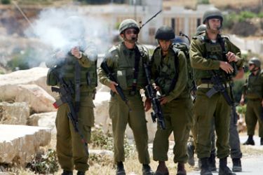 Israeli soldiers fire tear gas canister towards Palestinian and foreign peace activists during a demonstration against the construction of a section of Israel's controversial separation barrier in the West Bank village of Maasarah, near the biblical West Bank town of Bethlehem, on May 21, 2010.