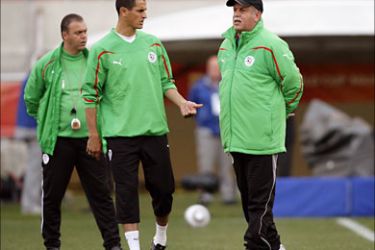 epa02198759 Algerian national soccer team head coach Rabah Saadane (R) talks with his forward Rafiq Saifi (C) during their team's training session at the Peter Mokaba