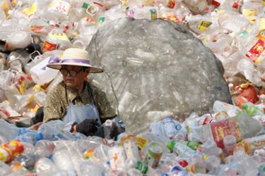 A woman cleans and sorts plastic bottles at a recycling centre on the World Environment Day in Huaibei, Anhui province