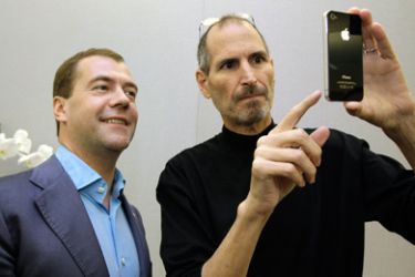 Apple chief executive Steve Jobs (R) shows an iPhone 4 to Russia's President Dmitry Medvedev during his visit to Silicon Valley in Cupertino June 23, 2010. Medvedev