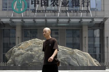 A pedestrian walks in front of the headquarters of Agricultural Bank of China in Beijing June 4, 2010. The China Securities Regulatory Commission plans to release