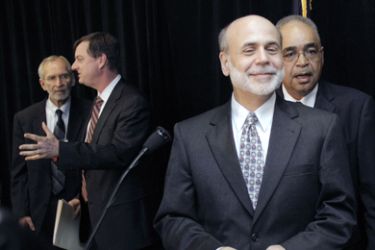 Federal Reserve Chairman Ben Bernanke (R) attends a discussion panel after speaking at the Detroit Branch of the Federal Reserve Bank of Chicago