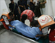مسعفون فلسطينيون يحملون جثمان الشهيدة نعيمة (الفرنسية)  