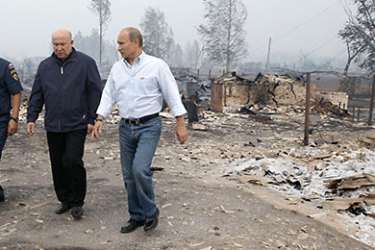 : Russian Prime Minister Vladimir Putin (C) speaks with local residents who lost their homes while touring the scene of fire damage near Nizhny Novgorod on July 30, 2010. Eight people died in forest fires in Russia's worst heatwave in decades, officials said as Prime Minister Vladimir Putin visited one