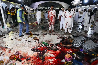 Pakistani devotees stand beside the bodies that lie on the floor after the suicide bomb attacks at the Saint Syed Ali bin Osman Al-Hajvery shrine, popularly known as Data Ganj Bakhsh in Lahore on July 2, 2010. At least 25 people were killed on July 2 in three suicide attacks at the tomb of an Islamic saint in the eastern Pakistani city of Lahore, police said. AFP