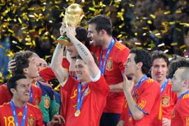 Spain's striker Fernando Torres (C) holds up the trophy as he celebrates with teammates during the award ceremony following the 2010 FIFA football World Cup between the Netherlands and Spain on July 11, 2010 at Soccer City stadium in Soweto, suburban Johannesburg. Spain won the match 1-0. NO PUSH TO MOBILE / MOBILE USE SOLELY WITHIN EDITORIAL ARTICLE - AFP PHOTO