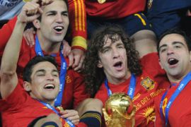 Spain's midfielder Cesc Fabregas (L, top), striker Jesus Navas, defender Carles Puyol (2-R) and Spain's midfielder Xavi (R) celebrate with the FIFA World Cup trophy after winning the 2010 World Cup football final by defeating The Netherlands during extra time at Soccer City stadium in Soweto, suburban Johannesburg on July 11, 2010.