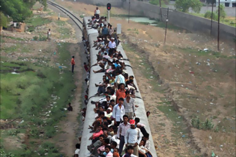 People travel on a crowded passenger train on the eve of "World Population Day" in the northern Indian city of Lucknow
