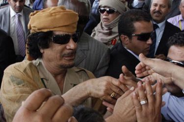 Libyan leader Moamer Kadhafi (L) is greeted by wellwishers upon his arrival at the airport at Entebbe international airport on July 24, 2010. Ugandan forces imposed tight security as more than 30 heads of state began converging on Kampala for an African Union summit barely two weeks after deadly suicide attacks