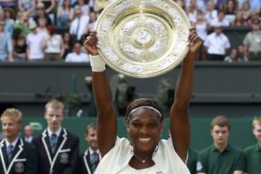 Serena Williams of the U.S. poses for photographers as she holds the winners trophy after defeating Russia's Vera Zvonareva in the womens' singles final at the 2010 Wimbledon tennis championships in London, July 3, 2010.