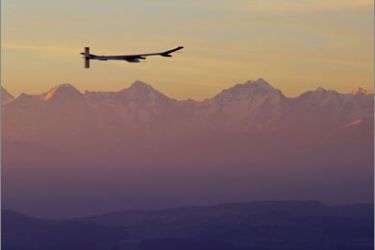 Experimental aircraft "Solar Impulse" with pilot Andre Borschberg onboard flies at sunrise with a view of the Swiss Alps in the background above Payerne's Swiss