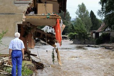 POLAND : A resident of Bogadynia looks on as his son checks the demaged to their house on August 8, 2010 in Bogadynia, southern Poland. Eight people died and thousands were evacuated amid disrupted traffic and power outages as floods hit parts of central Europe following heavy rainfall on A
