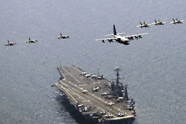 This US Navy photo shows a US Marine Corps C-130 Hercules aircraft as it leads a formation of F/A-18C Hornet strike fighters and A/V-8B Harrier jets on July 27, 2010 in the East Sea over the aircraft carrier USS George Washington