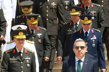 Turkey's Prime Minister Tayyip Erdogan (R) leaves after a wreath-laying ceremony as he is flanked by Chief of Staff General Ilker Basbug