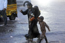 An Indian woman walks with her children during a heavy downpour in Hyderabad on August 17, 2010. Heavy rains battered several districts with the southwest monsoon remaining vigorous over the southern Indian state of Andhra Pradesh