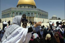 afp : A Palestinian woman splashes cold water on fellow worshippers to cool down during the third Friday noon prayer of the holy fasting month of Ramadan at the Al-Aqsa mosque compound in Jerusalem on August 27, 2010 .AFP