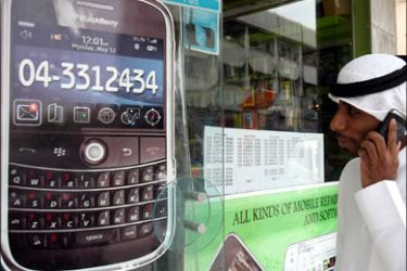 afp : A man walks past a sign advertising the BlackBerry mobile phone at a shopping mall in Dubai on August 01, 2010, as the Gulf business hub stated it will suspend key