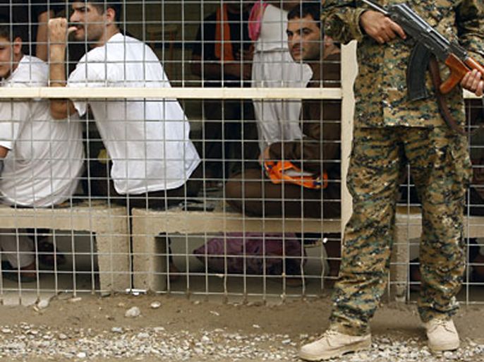 File picture dated April 29, 2010 shows an Iraqi soldier standing guard in front of prisoners waiting to be released from Al-Rusafa detention facility in Baghdad. Tens of thousands of detainees are being held without trial in Iraqi prisons and face violent and psychological abuse
