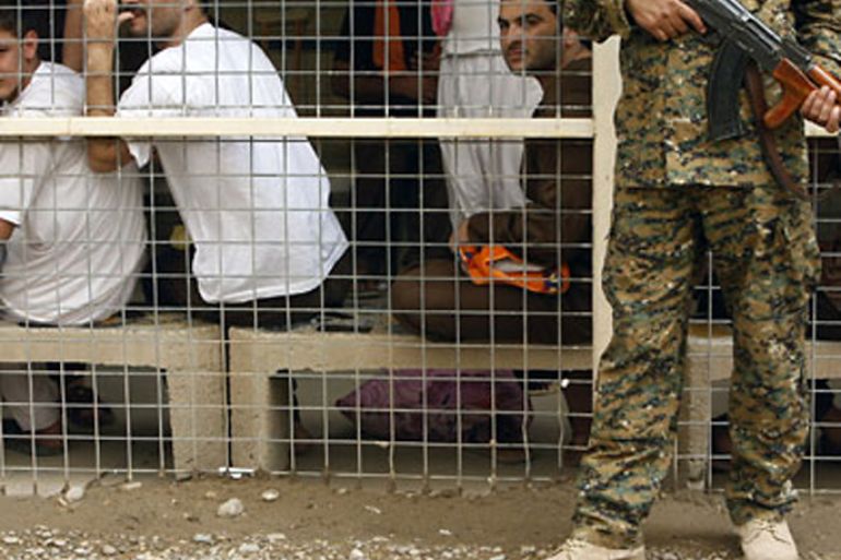 File picture dated April 29, 2010 shows an Iraqi soldier standing guard in front of prisoners waiting to be released from Al-Rusafa detention facility in Baghdad. Tens of thousands of detainees are being held without trial in Iraqi prisons and face violent and psychological abuse