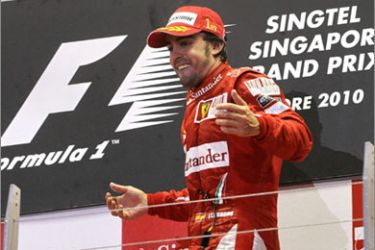 Ferrari driver Fernando Alonso of Spain celebrates on the podium after his victory in Formula One's Singapore Grand Prix at the Marina Bay Street Circuit in Singapore on September 26, 2010. Alonso won an incident-packed Singapore Grand Prix ahead of Red Bull's Sebastian Vettel to put the world championship title race on a