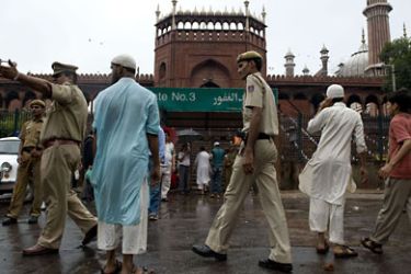 policemen guard the area around gate number three of the Jama Masjid mosque after foreign tourists were attacked by unknown gunmen in New Delhi on September 19, 2010. Gunmen opened fire on a tourist bus near the main mosque in New Delhi
