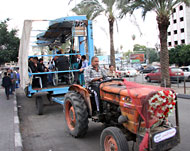 حافلات العرسان المفتوحة طافت بهم بالمدينة وسط تصفيق المواطنين (الجزيرة نت)