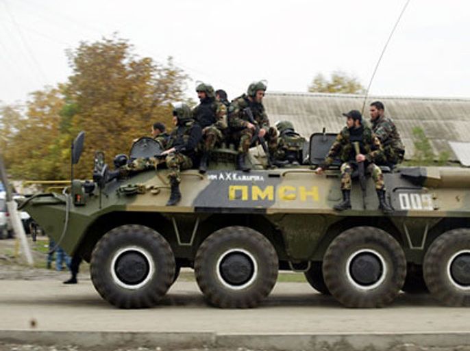 Chechen special forces ride on a top of an APC near the parliament building in Grozny on October 19, 2010