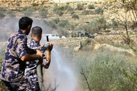 Palestinian firemen extinguish fire from a Palestinian olive tree field after it was set ablaze by Jewish settlers in the West Bank village of Hussan, near the Israeli settlement of Beitar Illit