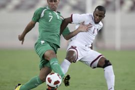 Iraq's Emad Mohammed (L) fights for the ball with Qatar's Meshaal Mubarak during an international friendly soccer match in Doha October 12, 2010.