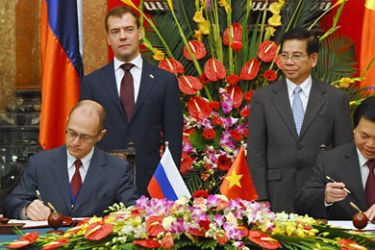 Visiting Russian president Dmitry Medvedev (L, standing) and his Vietnamese counterpart Nguyen Minh Triet (R, standing) witness the signing of the agreement on building a nuclear power plant in Vietnam by Sergey Kiriyenko (L), General Director of Russia's Rosatom group and Vietnamese Minister of Trade and Industry Vu Huy Hoang on October 31, 2010 at the presidential palace in Hanoi.