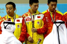 Emirati officials decorate the world's number One Chinese Ma Long with a medal at the podium after the Chinese team won the finals of Table Tennis World Team Cup 2010 against South Korea in Dubai, October 01, 2010. China beat South Korea 3-0 to grab the world title. AFP