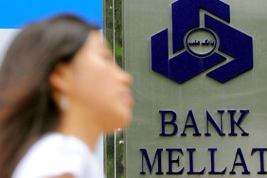 : (FILES) In a file picture taken on September 8, 2010 a woman walks past a signboard of Bank Mellat, an Iranian state-run commercial bank, outside its Seoul branch in Seoul. South Korea will suspend the operations of an Iranian bank for two months, financial regulators said on October 7, as part of international sanctions over Tehran's suspected nuclear weapons programme.