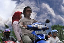 Local residents leave a danger zone as Merapi volcano releases ash clouds in Balerante village, Klaten on November 1, 2010. Indonesia's most active volcano which has claimed at least 36 lives last week spewed more searing clouds of gas and ash on October 31, triggering fresh panic among locals.