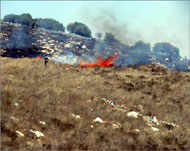 المستوطنون يحرقون أراضي مزروعة بالزيتون في قرية بورين قبل أيام (الجزيرة نت)