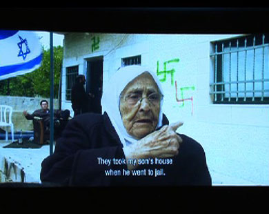 لقطة من الفيلم الوثائقي يعرض فلسطينية تتكلم عن مصادرة بيتها (الجزيرة نت)