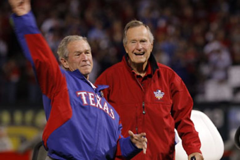 Former President George W. Bush, accompanied by his father Former President George H. W. Bush, throws out the first pitch of game 4 of the World Series in Texas.
