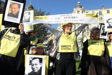 Amnesty International's demonstrators hold pictures of the 2010 Nobel Price Liu Xiaobo during a demonstration to protest against the state visit to France by Chinese President Hu Jintao on November 5, 2010 in Nice southern France