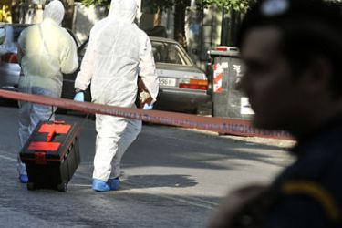 Police investigators collect evidence after the bomb exploded inside the headquarters of courier company Swiftmail, lightly injuring a female employee who is in no immediate danger, in the Athens suburb of Pangrati on November 1, 2010