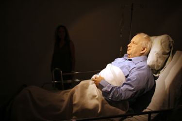 A woman looks at a life size model of former Israeli Prime Minister Ariel Sharon lying in a hospital bed, exhibited at the Kishon gallery in Tel Aviv, Israel, 21 October 2010. The artist, Israeli Noam Braslavsky,