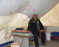 محمد عبد ربه يجلس في خيمة على أنقاض منزله المهدم في عزبة عبد ربه (الجزيرة نت)