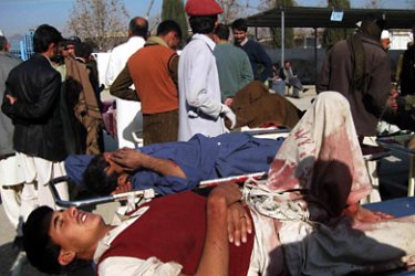 Pakistani paramedics treat injured victims of the suicide attack bombing outside the hospital of Khar