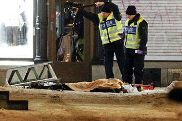 Police forensics experts examine the remains of a suspected suicide bomber in Stockholm on December 11, 2010.
