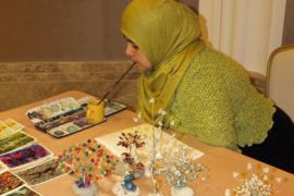 الفنانة التشكيلية الليبية التي ترسم بالفم زهرة البيباص ،والتعليق البيباص قدرة "نادرة" ترسم بالفم ( الجزيرة نت)
